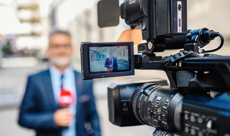 Camera filming journalist