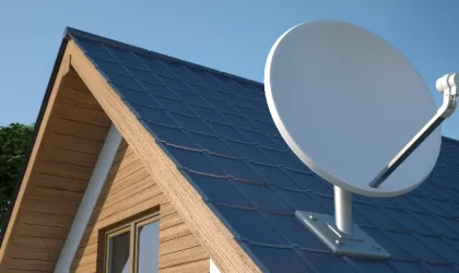 Find TV channel and point antenna Roof of wooden house in rural location with satellite dish